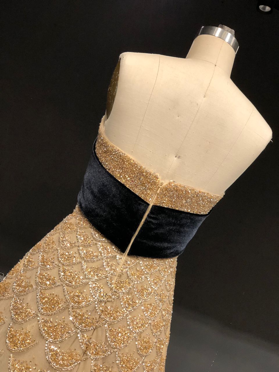 Strapless gold gown with crystal scales and a velvet bow