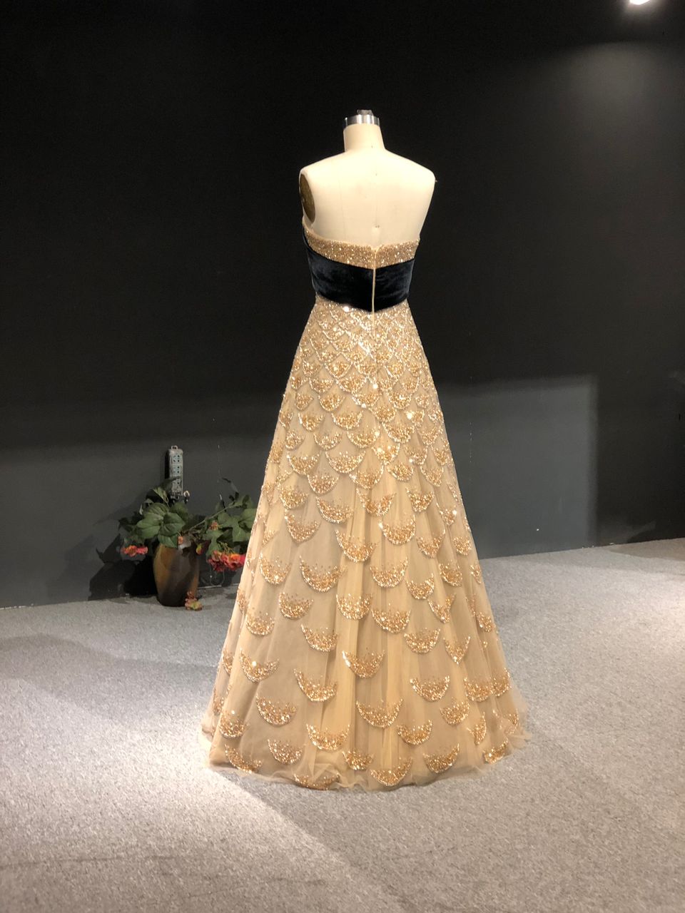Strapless gold gown with crystal scales and a velvet bow