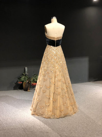 Strapless gold gown with crystal scales and a velvet bow