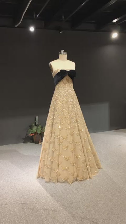 Strapless gold gown with crystal scales and a velvet bow